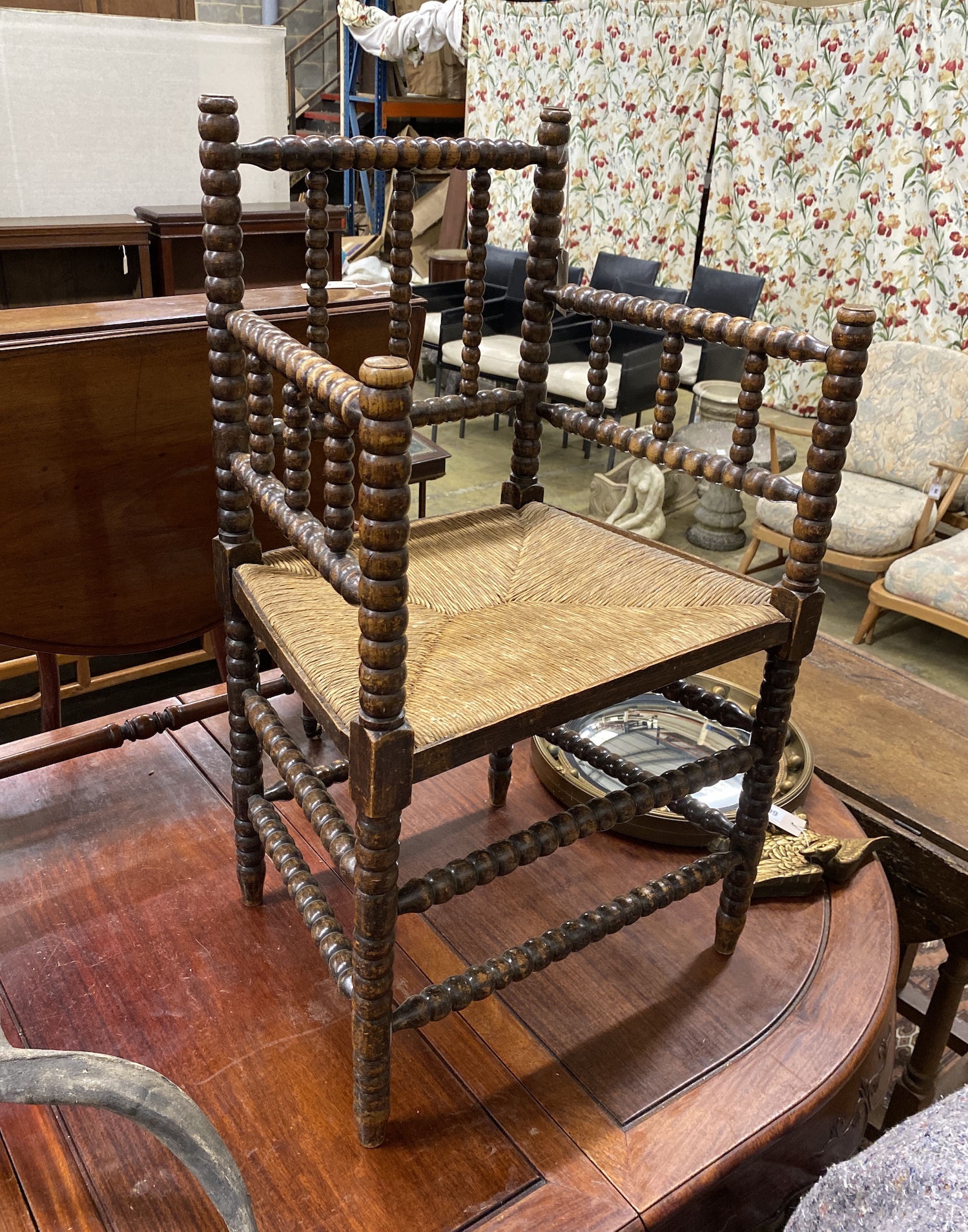 A late Victorian beech bobbin turned rush seat elbow chair, height 90cm.